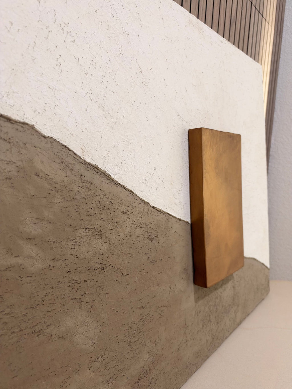 KR 05 Drought handmade plaster wall art, angled view showing the raised bronze-and-gold block | ACAYA Studio