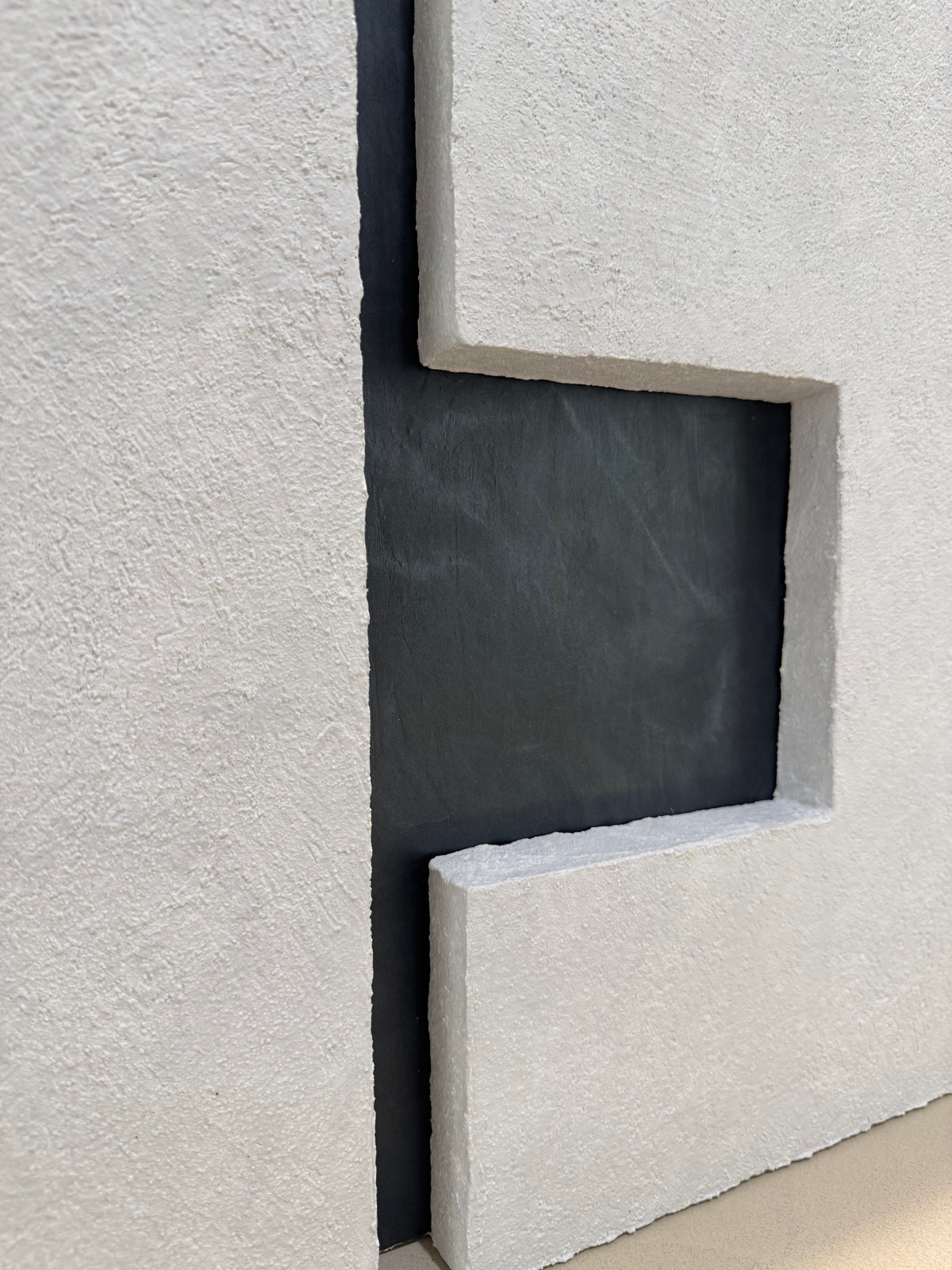 TS 03 Current, alternate angle — two pale stone planes separated by a recessed gunmetal passage | ACAYA Studio Tsitsikamma collection
